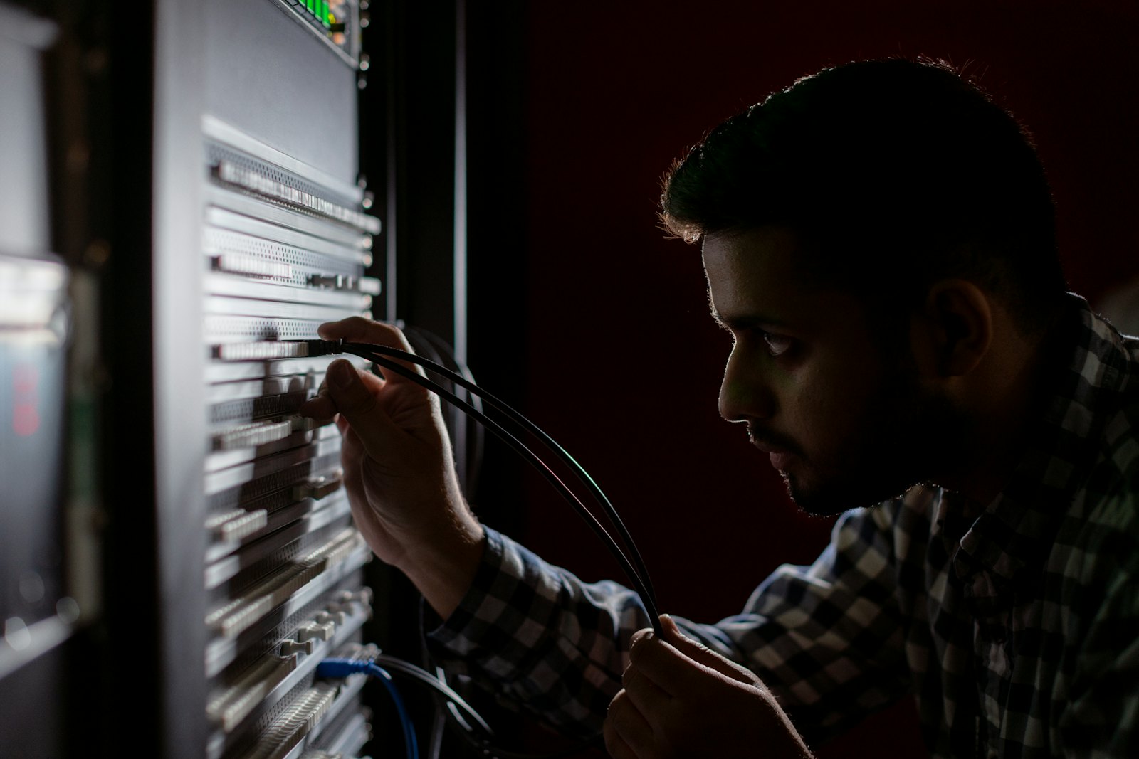Technician working on network cabling in a rack
